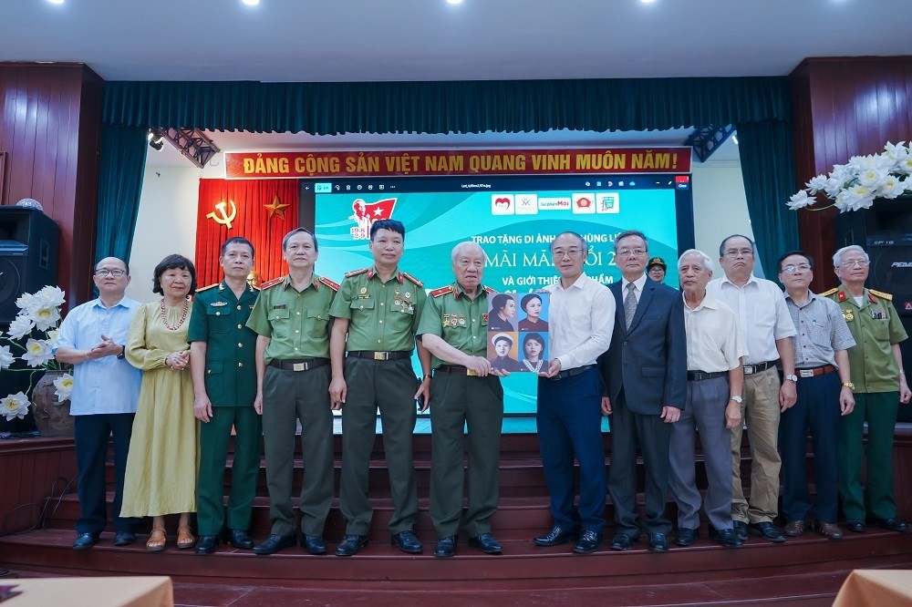 Anh hùng LLVT Phan Văn Lai trao tượng trưng 4 di ảnh nữ AHLS đầu tiên của lực lượng Công an Nhân dân cho Bảo tàng Phụ nữ Việt Nam. Ảnh: BTC