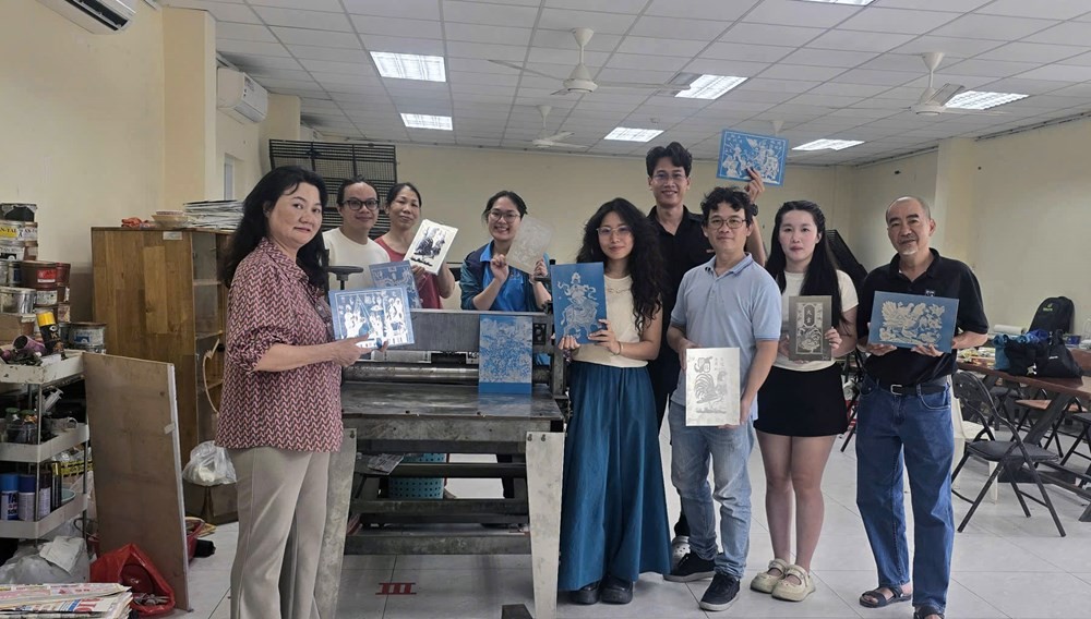 Họa sĩ Nguyễn Ngọc Vinh trong quá trình cùng đồng nghiệp thực hiện các tác phẩm. Ảnh: TGCC