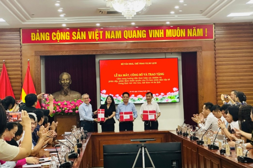 Thứ trưởng Phan Tâm trao tặng Cẩm nang hướng dẫn thực hiện các nhiệm vụ phân cấp, phân định thẩm quyền cho UBND cấp xã trong lĩnh vực VH-TT-DL. Ảnh: Báo VH