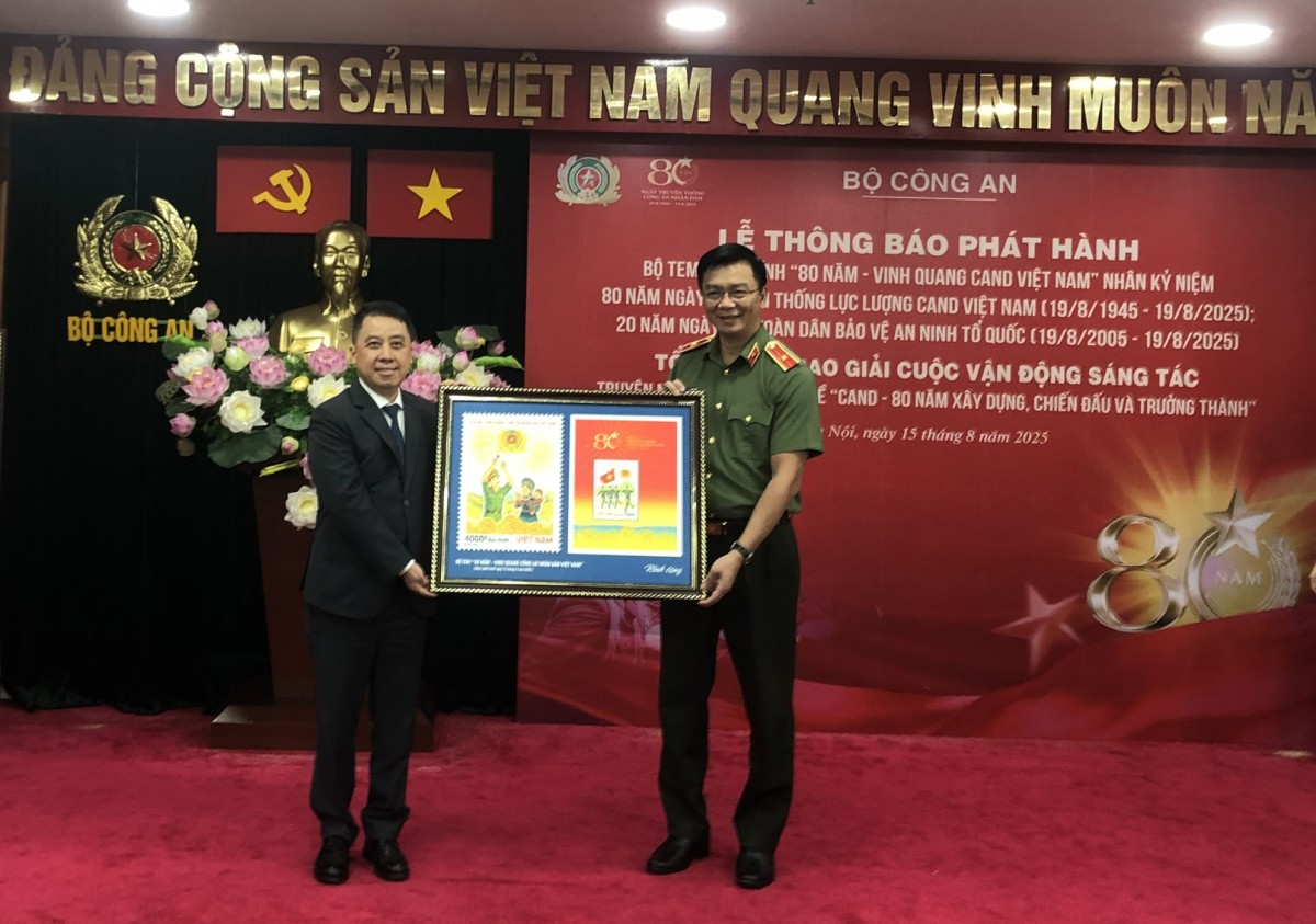 Thiếu tướng Phạm Kim Đĩnh trao bộ tem cho đồng chí Lã Hoàn Trung, Vụ trưởng Vụ Bưu chính.