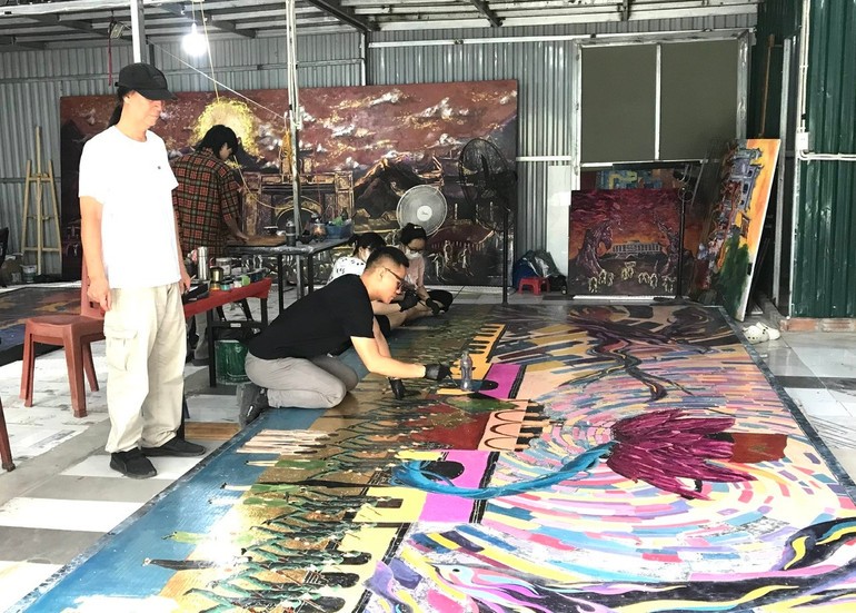 Họa sĩ Chu Nhật Quang trong quá trình hoàn thiện tác phẩm ﻿với sự góp ý của cha là Nghệ sĩ Ưu tú Chu Lượng. Ảnh NVCC