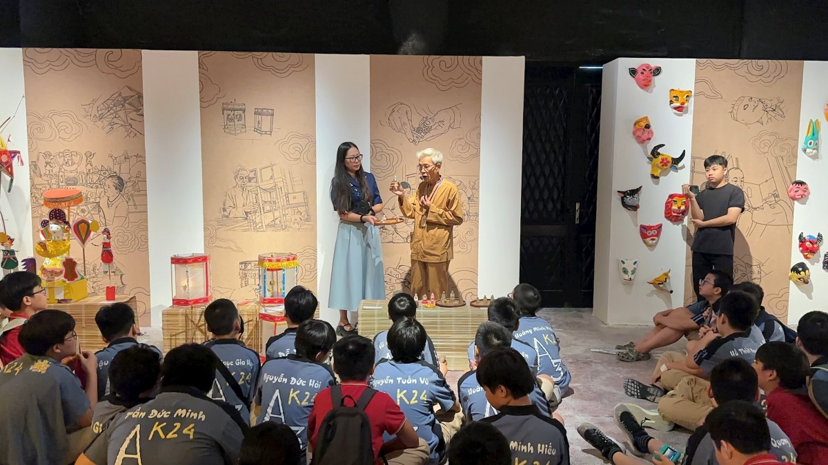 Nghệ nhân dân gian Phùng Đình Giáp chia sẻ với các em nhỏ về đồ chơi Phỗng đất. Ảnh: BTC