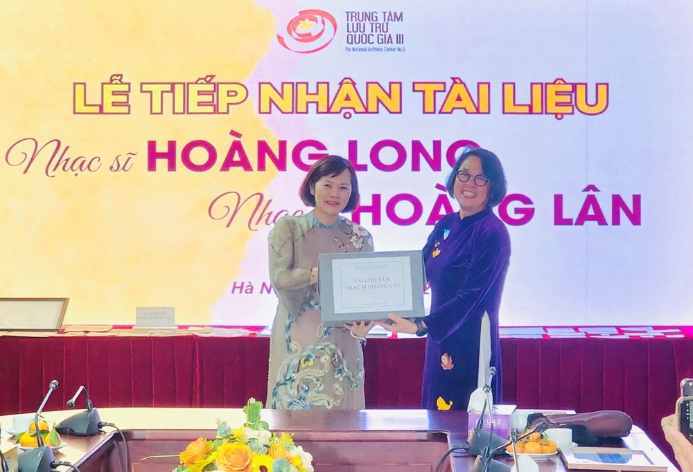 Đại diện Trung tâm Lưu trữ Quốc gia III - Tiến sĩ Trần Việt Hoa tiếp nhận trao tặng từ con gái nhạc sĩ Hoàng Vân - Tiến sĩ Y Linh (bên phải). Ảnh: BTC