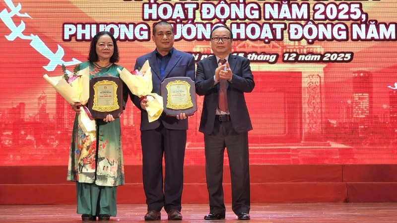 Nhà văn Nguyễn Xuân Tuấn (đứng giữa) và đại diện ủy quyền nhà văn Bành Thanh Bần (ngoài cùng bên trái) được trao giải thưởng Cống hiến sau nhiều đóng góp cho sự phát triển của văn học Thủ đô. Ảnh: N.D